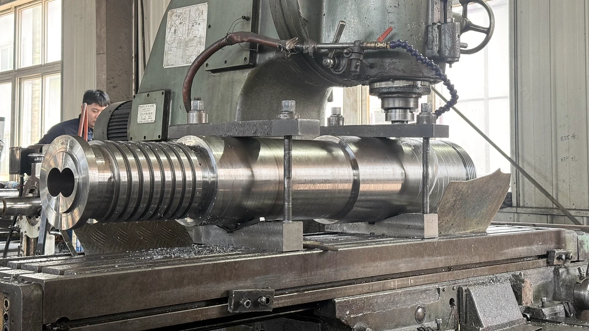 Twin-bore barrel component secured on a machining table beneath a cutting spindle