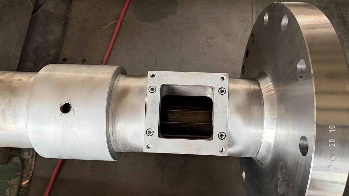 Rectangular feed opening and machined flange on a single-screw extruder barrel.