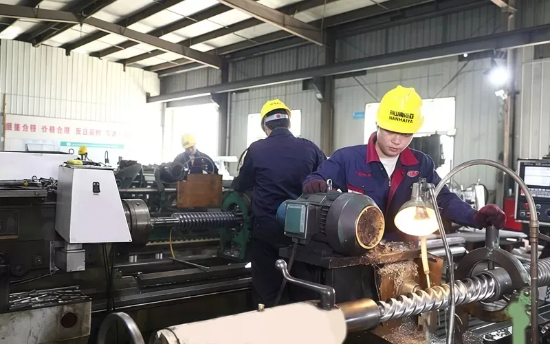 Workers machining precision screw shafts